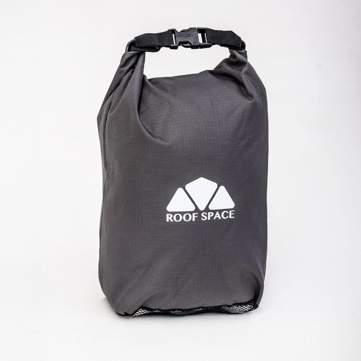 Ein grauer, wasserdichter Packsack mit dem Logo „ROOF SPACE“ steht vor einem weißen Hintergrund. Er hat einen schwarzen Tragegriff mit Schnalle oben.