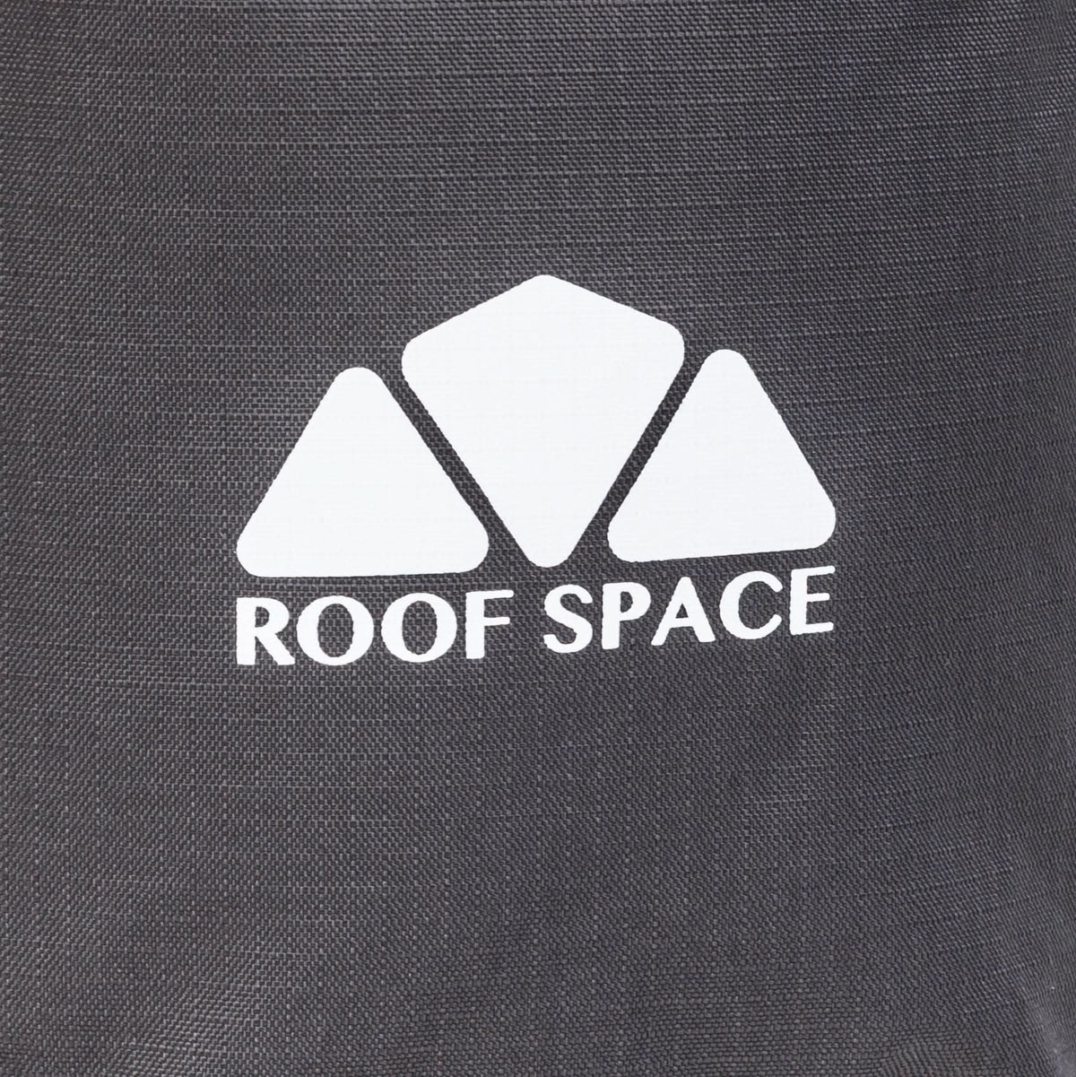 Nahaufnahme eines grauen Stoffs mit weißem „ROOF SPACE“-Logo und drei weißen, pyramidenförmigen Formen darüber.